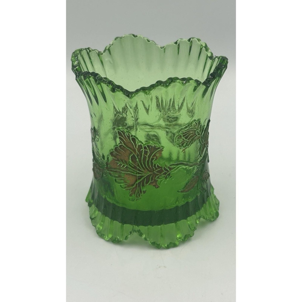 An Antique EAPG green glass spoon holder with gold floral overlay.